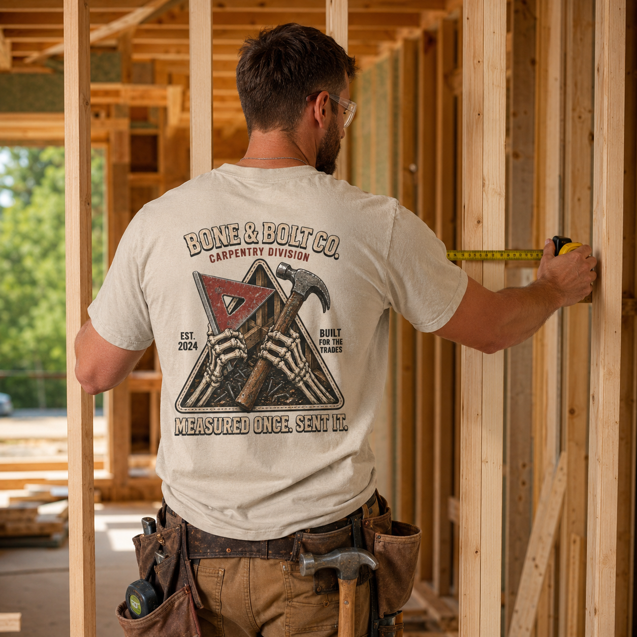 Carpenter wearing Carpentry Division tee while framing a house