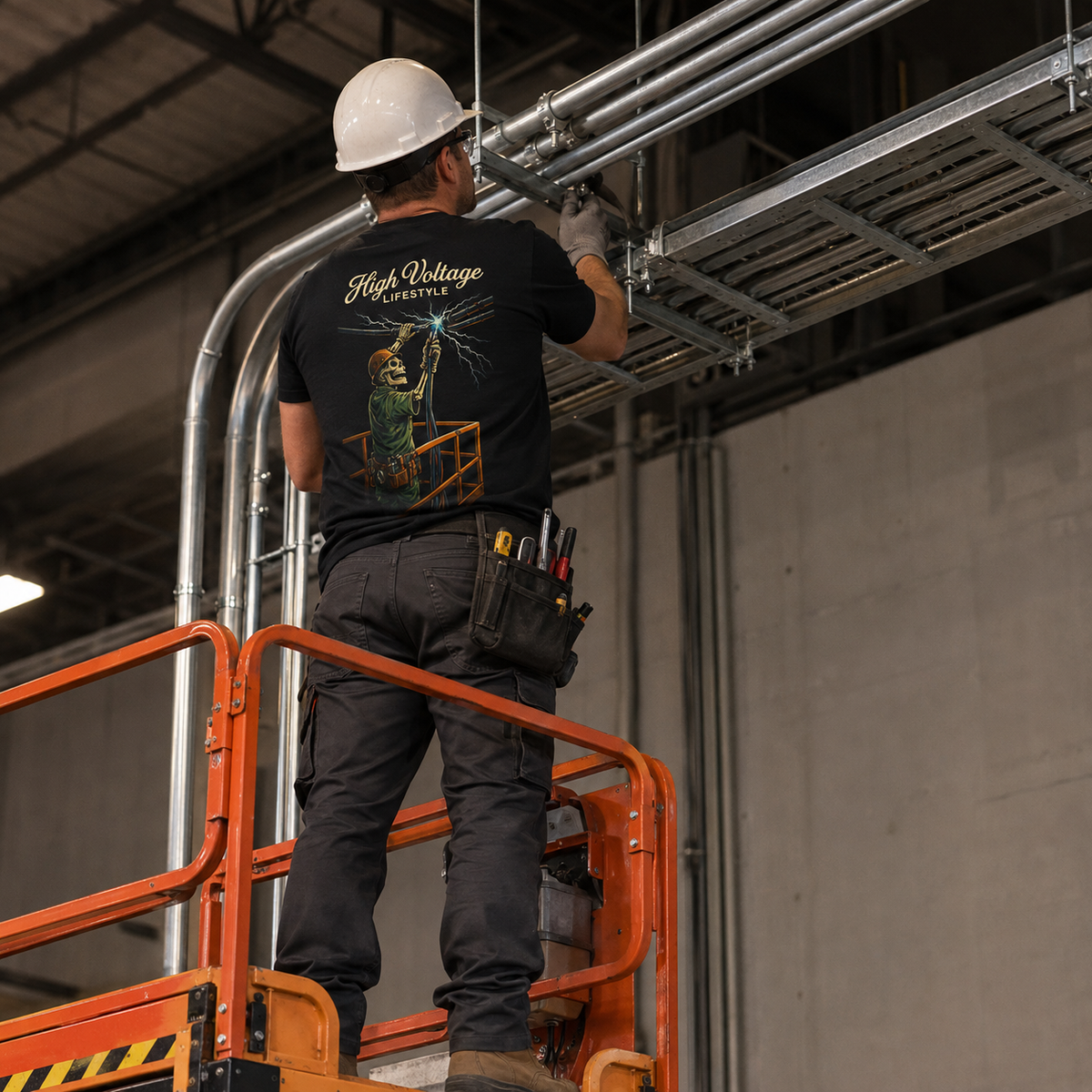 Electrician wearing High Voltage Lifestyle tee on an industrial lift