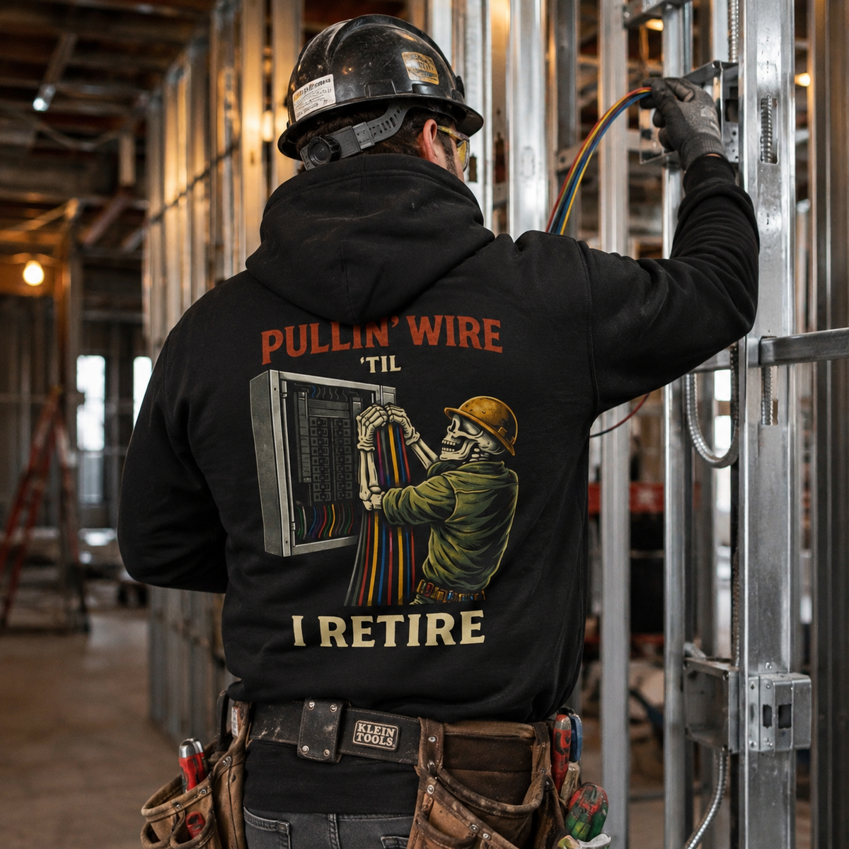 Electrician wearing Pullin Wire Til I Retire hoodie